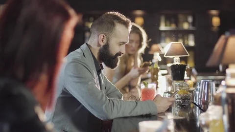 20s bearded guy people is drink cocktail sitting bar counter with menu Stock Footage 75238968
