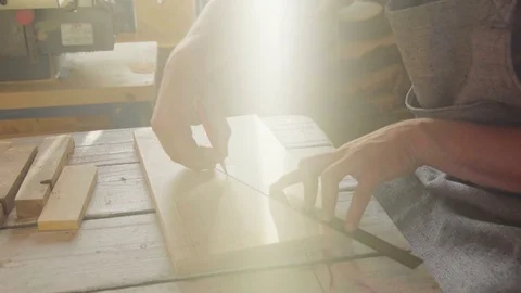 20s bearded man carpenter drawing on wooden board. sunny day in workshop Stock Footage 76106051