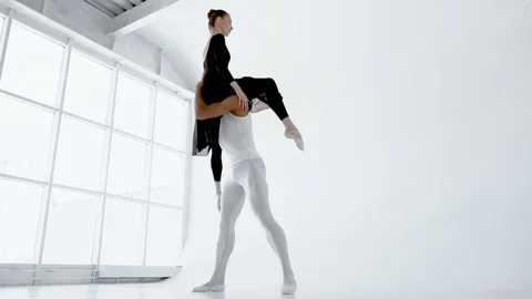 The 20s strong guy is holding a attractive brunette girl in his arms during the Stock Footage 77219760