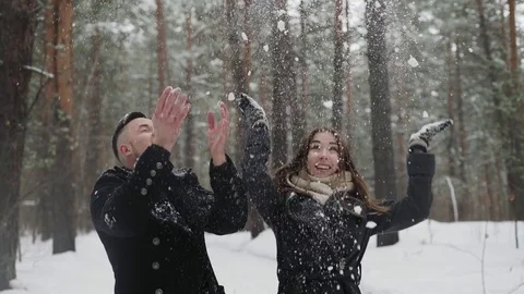 20s young couple is throw snow behind and have a fun in winter forest Stock Footage 73039898