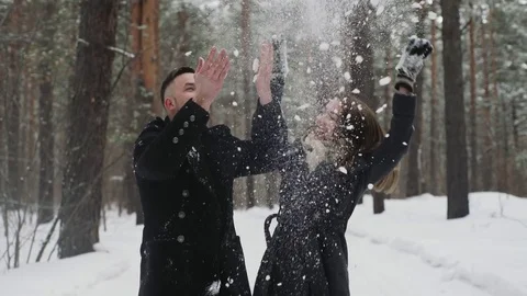 20s young couple is throw snow behind and have a fun in winter forest Stock Footage 73040264