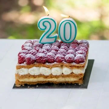 20th birthday raspberry cake with burning candles Stock Photos