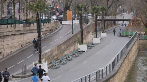 21 Rainy gray winter day Paris sports people running the Sena embankment in t Stock Footage 100814014
