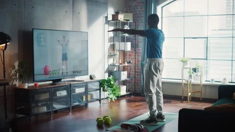 22 32 104 Man Repeating Exercises While Watching TV Stock Footage 197419304