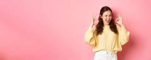Portrait of cheerful pretty girl winking and saying yes, showing okay sign, alright gesture, praise good job, well done, standing pleased against pink background. xkwx student, girl, background, okay, good, approve, alright, agree, yes, praise, woman, advertising, fashion, beauty, person, portrait, grinning, joy, pink, beautiful, joyful, pleased, positive, smile, stylish, studio, horizontal, young, gesturing, glamour, holiday, excited, shopping, isolated, adult, girlfriend, advertisement, casual, smiling, emotive, slim, upbeat, glamorous, cheerful, emotions, excitement, fashionable, brunette