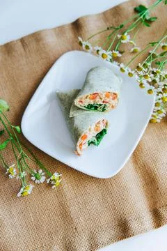 a vertical High angle closeup of a salmon wrap sliced in half xkwx appetizing, closeup, cooked, cuisine, cut, diet, dining, dinner, dish, eating, fish, food, fresh, half, healthy, high angle, lunch, meal, nutrition, plate, protein, recipe, salmon, sandwich, seafood, sliced, tasty, vertical, wrap