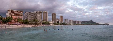 Honolulu,  Hawaii  -  December  29,  2022:  View  of  Waikiki  Beach  with  Diamond  Head  valcano  in  the  distance. xkwx architecture,  beach,  building  exterior,  city  life,  cityscape,  coastline,  diamond  head,  dusk,  famous  place,  hawaii,  hawaii  islands,  honolulu,  hotel,  island,  landscape  scenery,  mountain,  oahu,  ocean,  outdoors,  pacific  islands,  pacific  ocean,  panorama,  panoramic,  relaxation,  royal  hawaiian  hotel,  sand,  sea,  sky,  tourism,  tourist,  travel,  travel  destinations,  trees,  tropical,  tropical  climate,  twilight,  urban  skyline,  usa,  vacation,  waikiki,  waikiki  beach