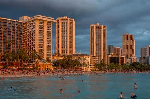 Honolulu,  Hawaii  -  December  29,  2022:  View  of  Waikiki  Beach  with  Diamond  Head  valcano  in  the  distance. xkwx architecture,  beach,  building  exterior,  city  life,  cityscape,  coastline,  diamond  head,  dusk,  famous  place,  hawaii,  hawaii  islands,  honolulu,  hotel,  island,  landscape  scenery,  mountain,  oahu,  ocean,  outdoors,  pacific  islands,  pacific  ocean,  panorama,  panoramic,  relaxation,  royal  hawaiian  hotel,  sand,  sea,  sky,  tourism,  tourist,  travel,  travel  destinations,  trees,  tropical,  tropical  climate,  twilight,  urban  skyline,  usa,  vacation,  waikiki,  waikiki  beach