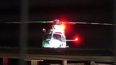 2.3.26: Toll Night Medical Retrieval Pilot Entering Helicopter as Rotors Start Stock Footage 330031253
