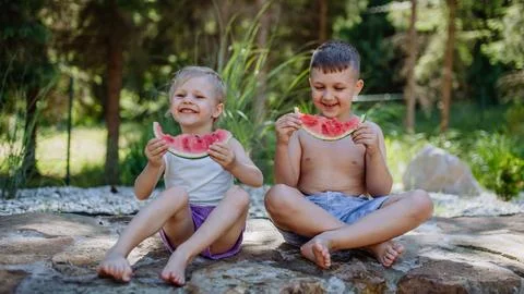 Little chidren sitting near a lake and eating watermelon on hot sunny day during summer vacation. xkwx happiness, watermelon, fruit, kid, happy, green, nature, red, food, fun, picnic, healthy, outdoor, joy, health, juicy, eat, girl, childhood, slice, boy, nutrition, cute, sweet, smile, little, eating, cheerful, snack, summertime, caucasian, meal, enjoy, outside, melon, garden, water, delicious, friend, refreshment, holiday, brother, sister, freshness, warm, preschool, siblings