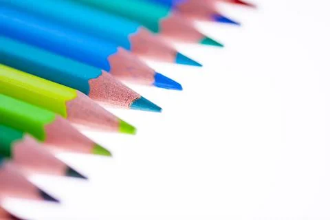 24 multicolored crayons on a white background, neatly arranged and sharpened. Stock Photos