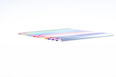 24 multicolored crayons on a white background, neatly arranged and sharpened. Stock Photos