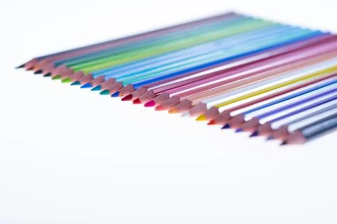 24 multicolored crayons on a white background, neatly arranged and sharpened. Stock Photos