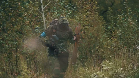 240 frames per second. A player in paintball moves through the forest with a pro Stock Footage 98860694