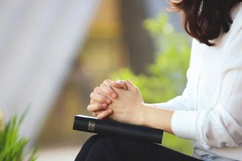 A Christian sitting on a bench in the park, meditating, praying, and worshiping with his hands folded over the Holy Bible xkwx Religion Bible nature green jesus holy bible person book prayer worship contemplation hands praying Christian sunshine cross Jesus Christ God faith church holy hope earnestly wish pray bright praying attitude cathedral Christianity Catholicism background sunlight gospel missions grace spirit symbol