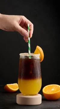 Iced coffee with orange juice in a transparent glass, refreshing bumble coffee on the table xkwx orange ocktail coffee cold cool drink espresso refreshment slice sweet syrup table yellow hold staw hand beverage black brown bumble caffeine citrus c fresh fruit glass ice juice juicy layer morning nobody
