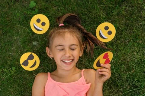 A teenage girl laughs loudly, squinting her eyes with pleasure, surrounded by a variety of emojis with different emotions xkwx emoji smile day emoticons world children faces emotion girl smiley kid laughter feelings heart different signs character happy message cute hidden little teenager facial expression mood creativity surprise lively person vigorous cartoon smiling set social media online chat positive nice various funny messenger face communication nature lying down baby portrait resilience merry cheerful