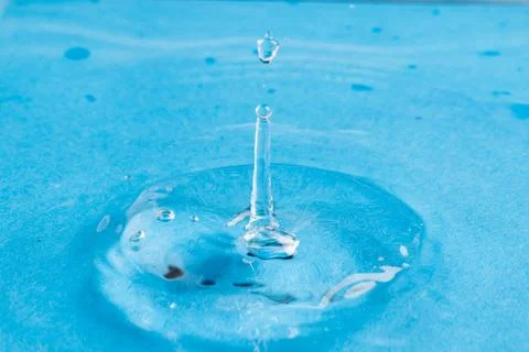 Close up of water drop falling into water with ripples and copy space on blue background. Water, liquid and colour concept. xkwx No People Close Water Drop Falling Water Ripple Copy Space Blue Background Liquid Colour Concept Drop Splash Abstract Design Background Wet Flow Fluid Closeup Wave Illustration Macro Business Graphic Symbol Isolated Flowing Color Clean Drink Water Falling Copy Space Blue