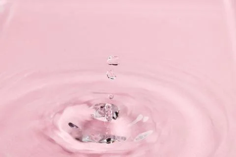 Close up of water drop falling into water with ripples and copy space on pink background. Water, liquid and colour concept. xkwx No People Close Water Drop Falling Water Ripple Copy Space Pink Background Liquid Colour Concept Drop Splash Abstract Design Background Wet Flow Fluid Closeup Wave Illustration Macro Business Graphic Symbol Isolated Flowing Color Clean Drink Water Falling Copy Space Pink