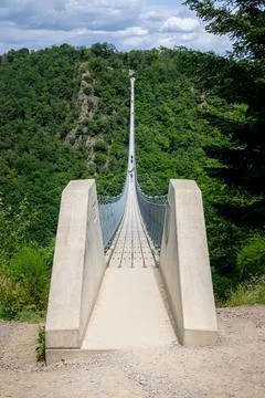 The Geierlay suspension bridge, the longest and most spectacular pedestrian bridge in Germany, near the village of Morsdorf in the Hunsruck region xkwx adventure blue bridge color image crossing europa forest geierlay geierlay bridge german germany green hanging hiking idyllic landscape moersdorf morsdorf mountain nature outdoor outdoors park path people pfalz rheinland rheinland-pfalz rhineland rhineland-palatinate scenics silk sky summer suspension suspension bridge tourism tourist trail travel tree trekking walk wood