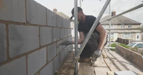 24p young man working on brickwork stood on scaffolding on a building site c Stock Footage 246382052