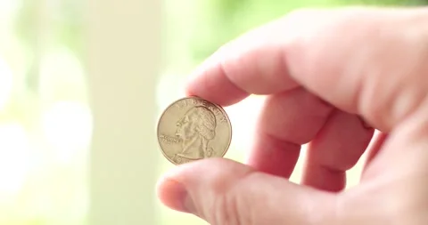 25 cents being held up by man's hand outside USA currency Stock Footage 207926894