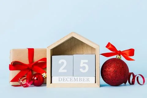 25 december. Christmas composition on colored background with a wooden cale.. Stock Photos