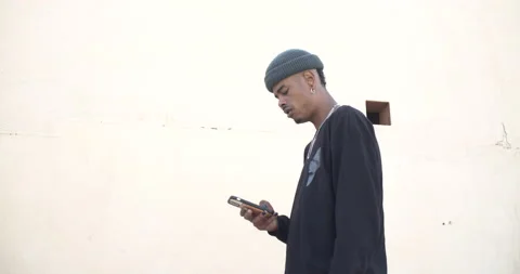 25-year-old afro man with hat and urban clothes chatting with a mobile phone Stock Footage 151484375