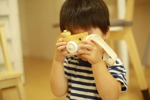 おもちゃのカメラで写真を撮る真似をする少年 Fotos Stock
