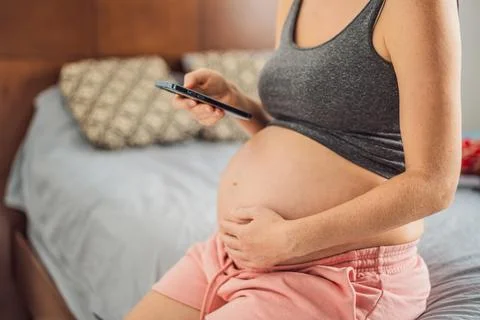 Mobile pregnancy online maternity application. Pregnant mother using phone. Pregnancy, medicine, pharmaceutics, health care and people concept. xkwx pregnant online pregnancy mother application woman app young technology maternity mobile cellphone phone internet beautiful belly expecting expectant home smartphone person abdomen connection motherhood communication anticipation sitting bedroom mockup programm concept tummy tablet family awaiting free space cheerful holding template cell screen bed blank reading african american mobile app care