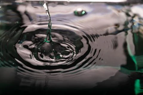 252.Falling Stream and Ripples on Dark Reflective Surface Stock Photos