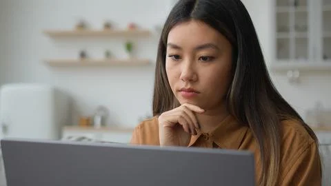 Smart pensive Asian chinese woman 30s businesswoman work from home kitchen thoughtful writer think business plan contemplate search media online on laptop doubtful korean girl thinking idea decision. High quality 4k footage xkwx think pensive asian woman dreaming chinese smart 30s businesswoman sit kitchen creative designer writer business plan contemplate search media online laptop doubtful korean girl thinking idea decide decision thoughtful create solution pondering puzzled searching ponder analyze thoughts confused problem contemplating concentrating doubt thought job planning solving startup computer internet