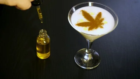 263 CBD oil bottle, drops of oil from a pipette in a cocktail, bar on a blac Stock Footage 125097262