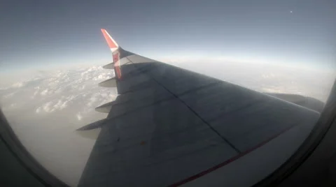 2.7K. Airplane wing out of window on blue sky background, Full HD. 2704x1524 Stock Footage 47809227
