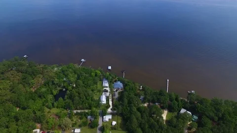 2.7K Drone Backing Up From Water Over Wooded Neighborhood Stock Footage 109229609