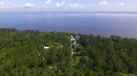 2.7K Drone Tilting Down Over Wooded Neighborhood Facing Bay 库存影片 109230376