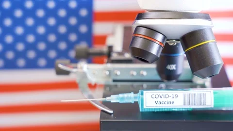 28614 The big syringe on the microscope with the coronavirus or Covid-19 vacc Stock Footage 128551995