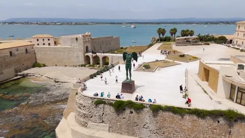 Circling the Mitoraj sculpture Isola Di Ortigia, Syracuse, Sicily - Aerial Drone Circling the Mitoraj sculpture Isola Di Ortigia, Syracuse, Sicily - Aerial Drone