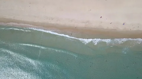 2K Aerial Drone Top Down view of green sea and white sand beach with blue Stock Footage 128029402