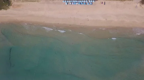 2K Aerial Drone Top Down view of green sea and white sand beach with blue Stock Footage 128029769