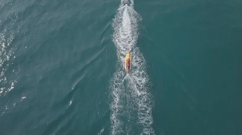 2K Aerial Top Down View of Jet Ski riding inflatable banana boat in green sea Stock-Footage 128029825
