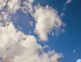 2K Film 24p Puffy clouds in crisp blue sunlit sky in timelapse Web Footage