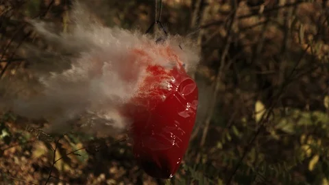 2K Super slow motion. The bullet hits the large bottle of colored water. Video stock 92538433