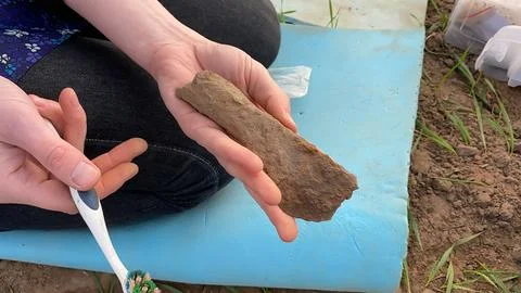 2nd 9th Century Socketed Axe and Brush Held in Bare Hands Foto stock
