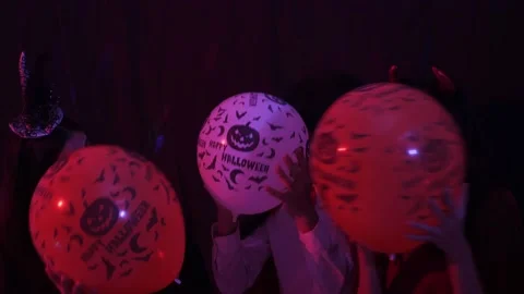 3 Asian teens dancing, playing peekaboo with balloon at Halloween party Stock Footage 138039055