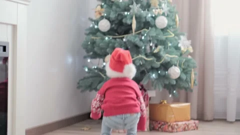 3 authentic happy Joy children wave hands hello rejoice by Christmas tree play Stock Footage 152897946