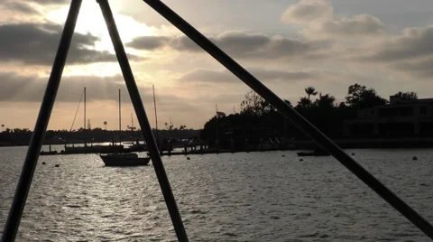 3 bimini supports frame the shot sun streaking through low clouds in harbor  Stock Footage 67467323
