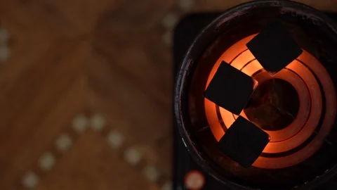 3 black square coals cook in special portable electric stove with red-hot spiral Stock Footage 125455633