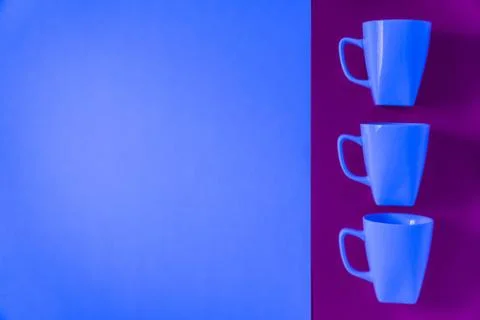3 blue winter coffee cup mugs lined up in a row for a break time meeting; Cop Stock Photos