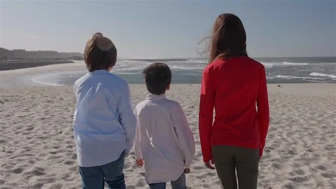 3 children walking on the beach towards the sea. Stock Footage 100587289